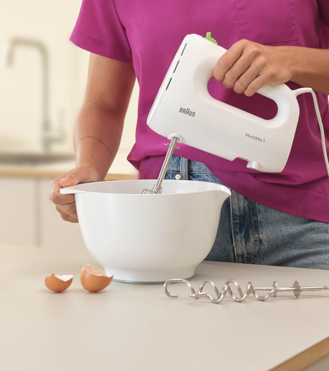 Woman mixing  dough with a white Braun MultiMix 1 Hand mixer